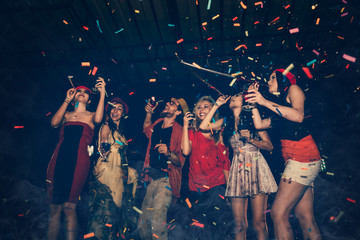 Cheerful Party - Group of Friends Enjoy Throwing Confetti and Dancing in Nightclub