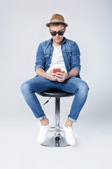 handsome man in denim sits on chair 