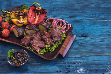 Grilled beef meat with vegetable on a blue wooden background