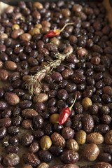 Baking fresh, colorful, organic olives, with rosemary, red hot peppers and mediterranean herbs, close-up, selective focus, space for text
