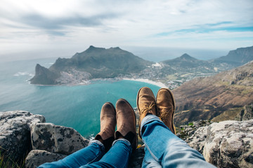 leather shoes and jeans of a relaxed hiking couple sitting at a mountain top