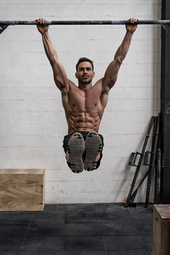 Man doing pull-ups in a gym