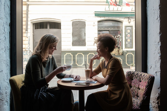 Two Female Friends Drinking Coffee At The Cafe