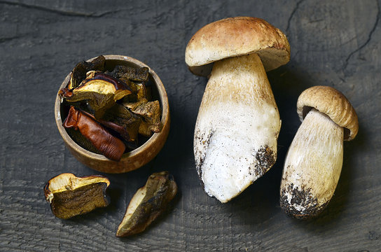 Boletus edulis mushrooms dried and fresh on old wooden table.Dried boletus mushrooms.
Gourmet food.Selective focus.