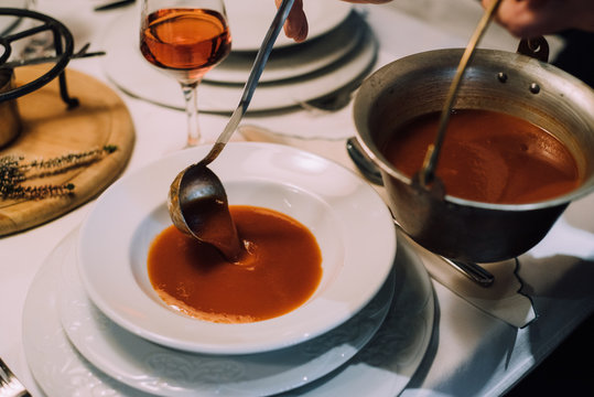 Waiter serving a potato soup