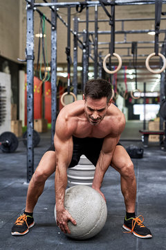 Man carrying a atlas stone in a gym