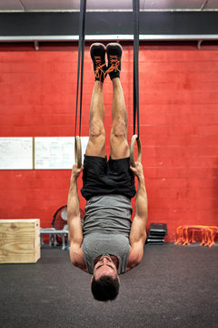 Man working out on rings in a gym