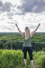 Woman arms raised up to sky
