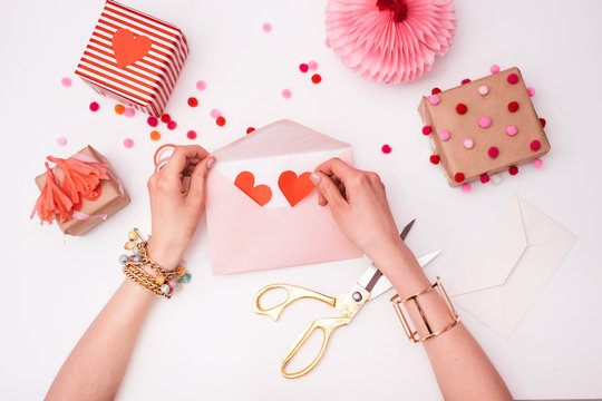 Woman Putting Red Hearts in a Pink Envelope