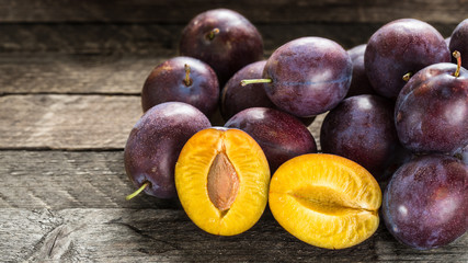Fresh blue plums on wooden table