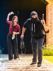 Beautiful woman throwing her shoes to the thief, who stole her handbag and running away. Selective...