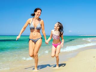 mutter rennt mit tochter den stand entlang