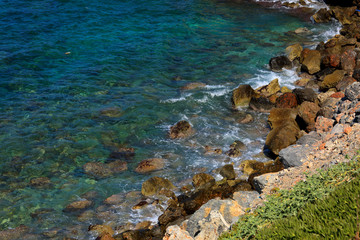 Fototapeta na wymiar Beautiful sea wave background on the stones near the shore and foam. Contrast portrait