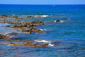 Beautiful blue sea wave background on the stones near the shore and foam. Contrast bright portrait