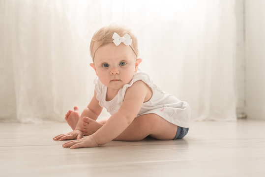 A Baby Sitting On The Ground