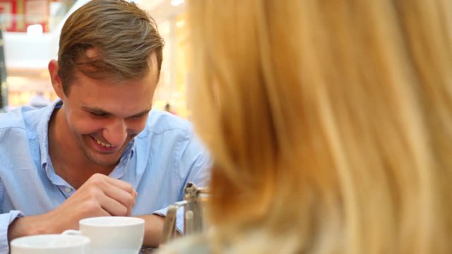 couple in cafe. Man and beautiful woman on a date are laughing. 4k, slow-motion, close-up. copy space