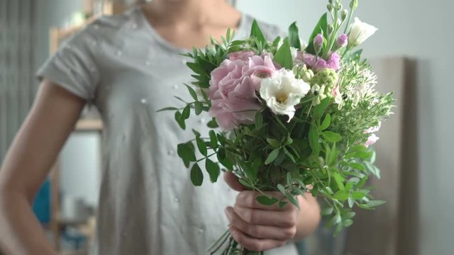 Girl florist cuts off the stems of flowers holding in her hand a bouquet in white and pink tones close-up 4k.