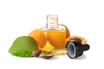Bottle of apricot oil with fresh fruit on white background