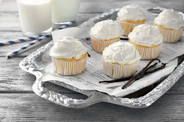 Tasty vanilla cupcakes on metal tray