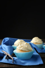 Tasty vanilla cupcakes on black background