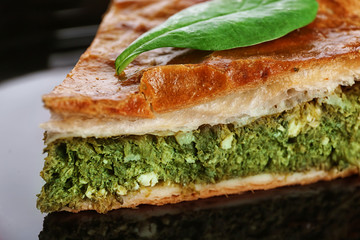Piece of tasty pie with spinach, close up