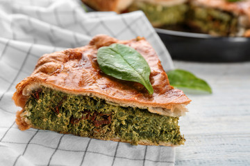 Piece of tasty pie with spinach on table