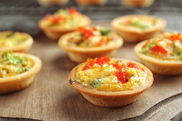 Broccoli quiche tartlets on wooden board