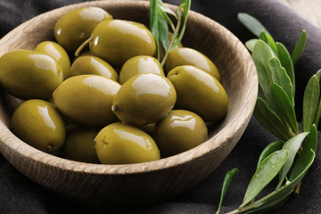 Bowl with green olives on cloth