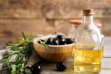 Composition with healthy olives and oil on wooden table