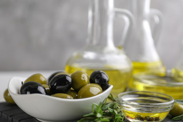 Bowl with healthy olives and oil on kitchen table