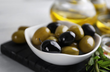 Bowl with healthy olives on kitchen table, closeup