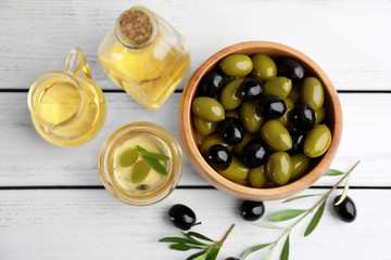 Composition with healthy olives and oil on wooden table