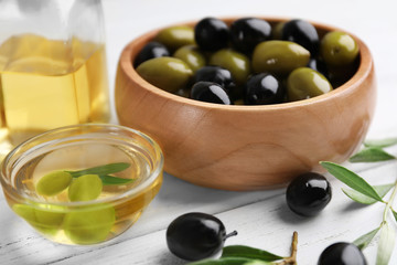 Bowls with olives and oil on wooden table
