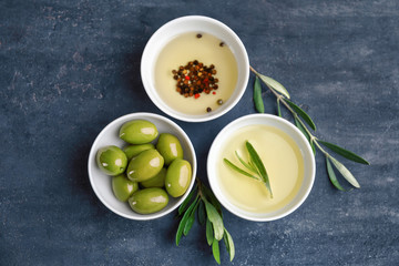 Bowls with healthy olives and oil on kitchen table