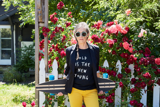 Portrait of stylish senior woman with long board