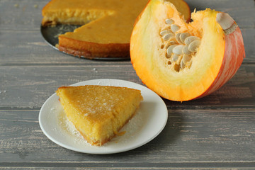 Pumpkin pie on grey wooden desk.