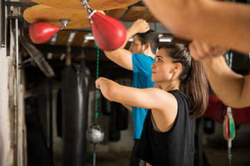 Group of people using speed bag in a boxing gym
