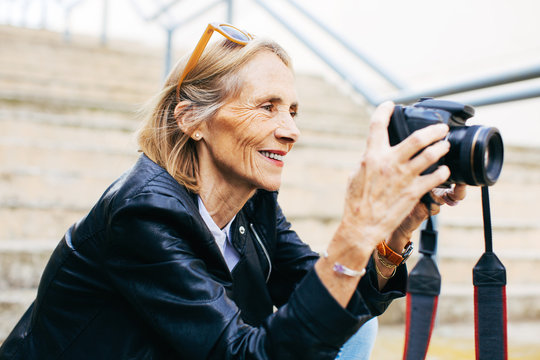 Retired woman taking photos of the city.
