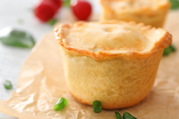 Delicious meat mini pie on parchment, closeup