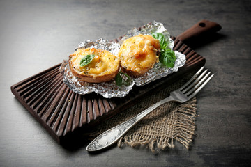Baked stuffed potatoes on wooden board