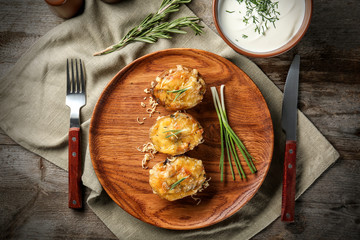Baked stuffed potatoes on wooden plate