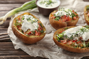 Baked stuffed potatoes on wooden table