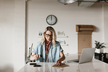 young woman stamping logo on paper in work space