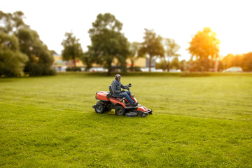 Men riding a lawnmower in a sunny day