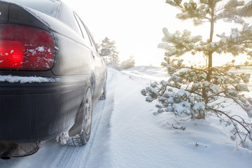 A car driving on a snowy rural road