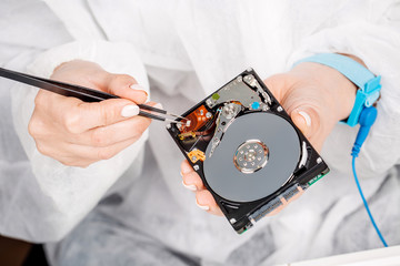 Obraz premium man repairing hard drive in service center. Repairing and fixing service in lab. Electronics repair service concept.