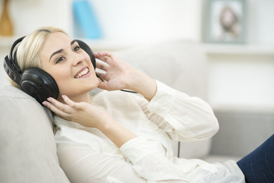 The young woman listen to the music in the earphones