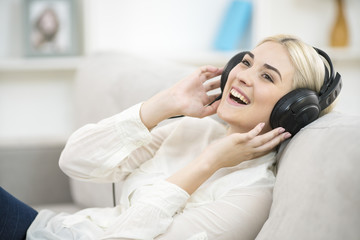 The young woman listen to the music in the earphones