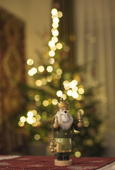 Traditional wooden incense figure in front of the Christmas tree