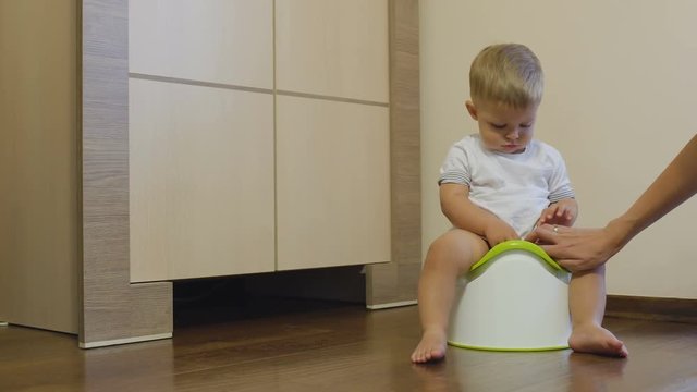 Pretty little boy pisses in his potty